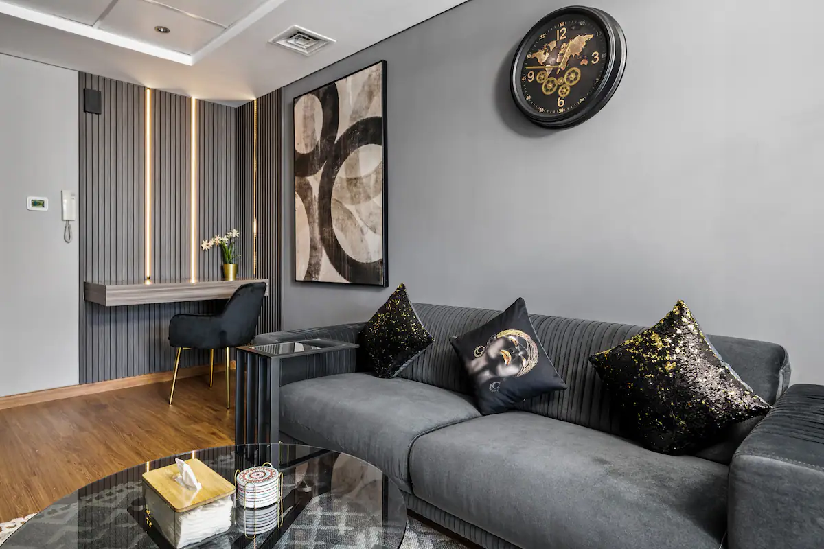 Modern living room with black sofa and glass coffee table.