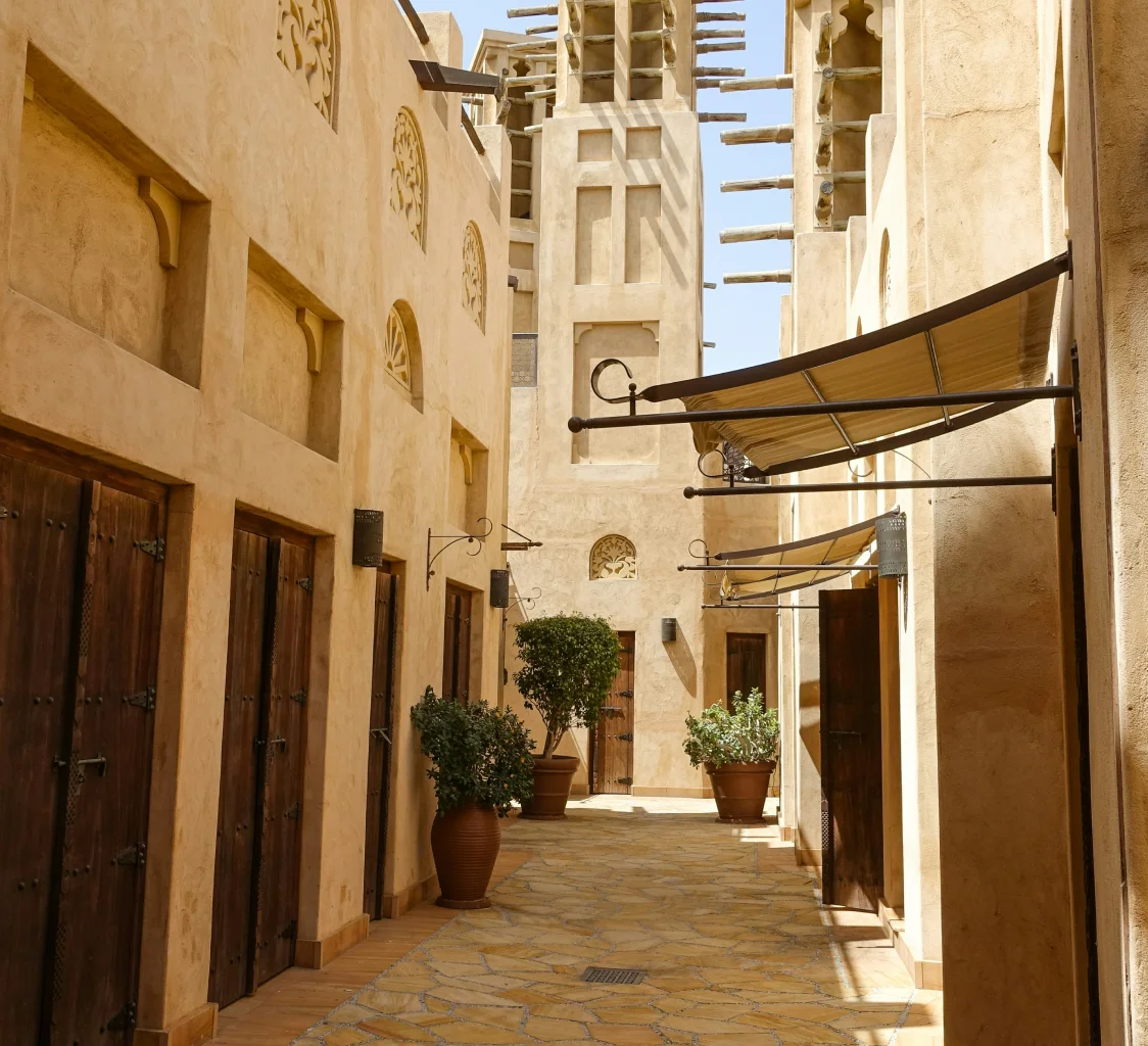 Narrow alley with stone walls and potted plants.